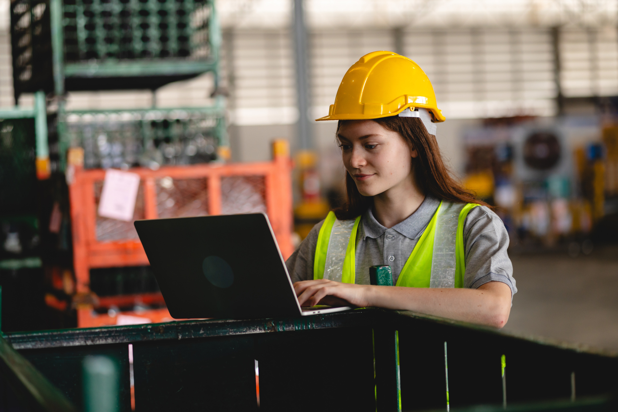 Female Engineer Using Laptop Computer For Safety Control Checks Or Manufacturing Maintenance Work In Factory Building Or Construction Site. Woman Engineer Inspector Working In Industry Product Line